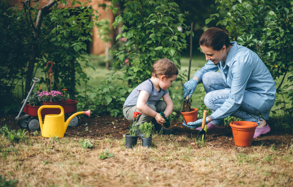 Young woman planting flower with her son